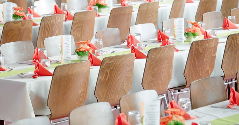 Empty rows of chairs and tables ready for corporate dining event