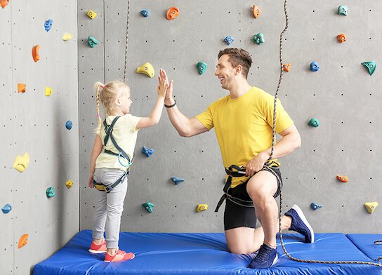Climbing instructor with girl student at climbing centre.